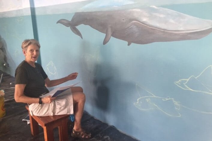 Artist and illustrator Carlyn Iverson, working on a mural in the Charles Darwin Exhibition Hall.