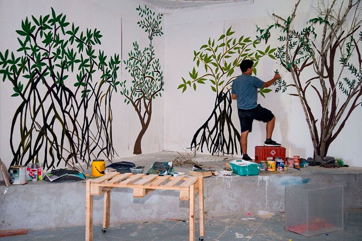 Jonathan Atiencia building a mangrove forest with recycled materials, rocks and lose branches.