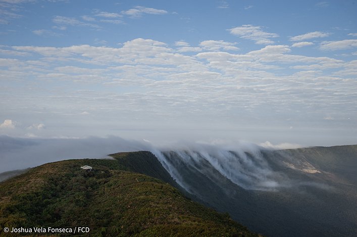 Clouds flowing into the crater of Alcedo Volcano. Notice the small hut at the edge of the crater (left). 