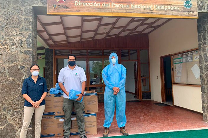 Johanna Carrión, representante de la Fundación Charles Darwin, entregando los trajes de protección a Danny Rueda, Director del Parque Nacional Galápagos y Cristian Sevilla, Dirección de Ecosistemas del Parque Nacional Galápagos.