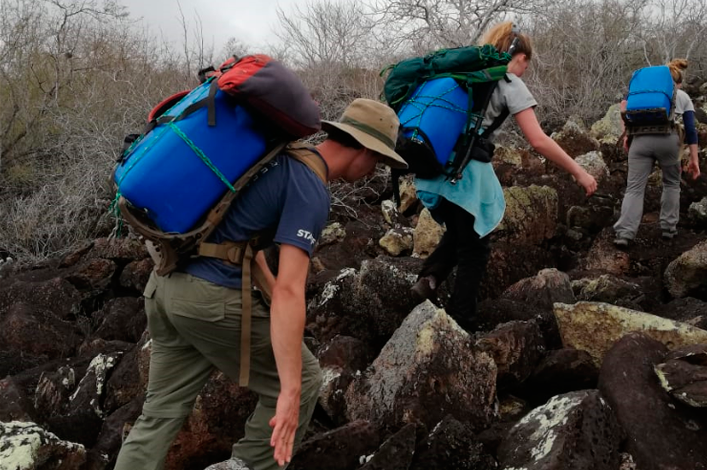 The team walking over the rocky terrain to the study site, with the ‘chimbuzos’ of water to fill the Groasis technology with