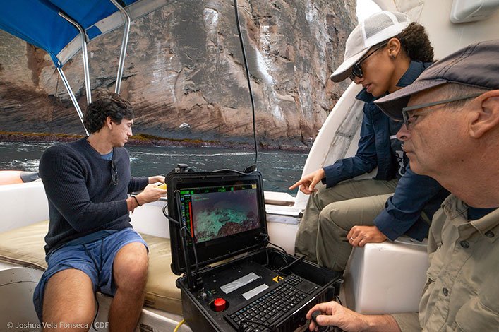 Tom Glebas piloting the ROV with a joystick from the control panel that live-streamed video footage from the deep